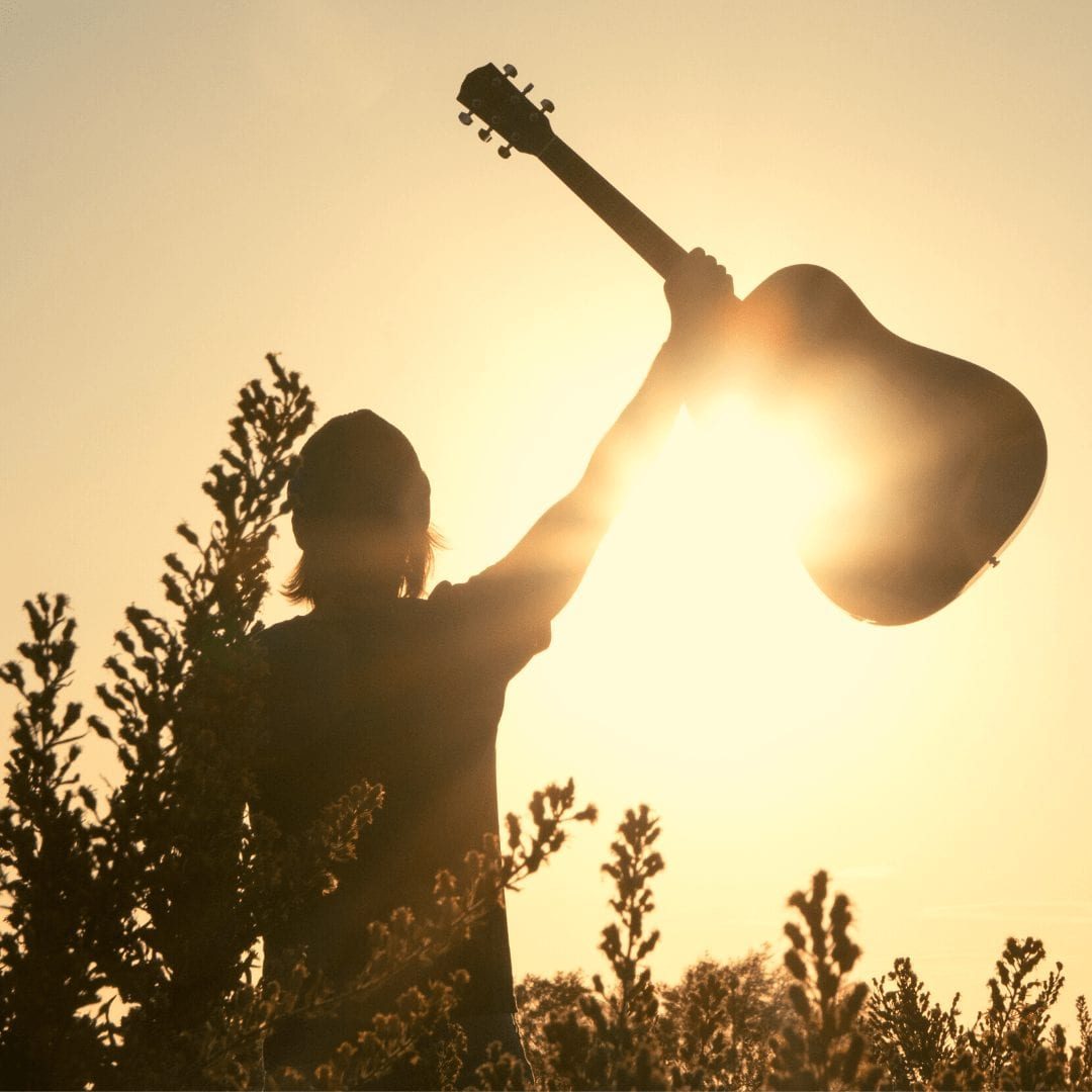 a logo image of a person holding a guitar high in triumph. The words "aspiring musician studio - where music and motivation merge" appears. music mentor